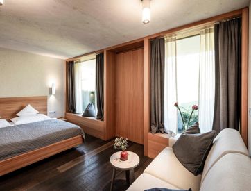 The sleeping area of the Suite Garmisch 1936 with a double bed and a couch