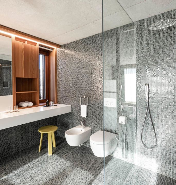 The modern and accessible bathroom of the apartments Cortina 1932 and Marmolata 1928 with a washbasin, shower, WC and bidet
