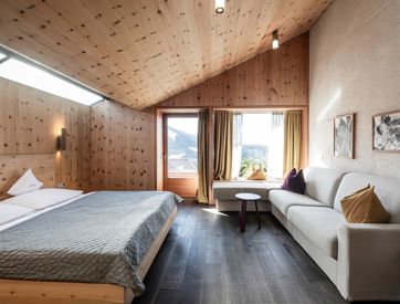 The bedroom of the apartment Santner 1929, with a double bed, big couch and balcony