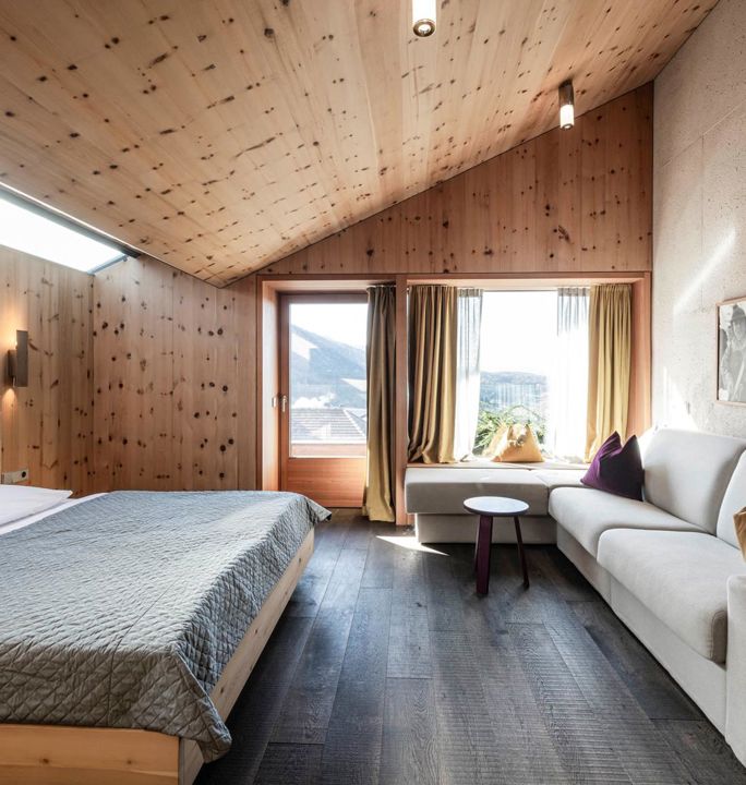 The bedroom of the apartment Santner 1929, with a double bed, big couch and balcony